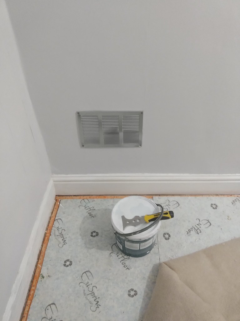 Profesional aplicando pintura en pared con rodillo
